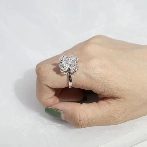 Silver floral four-heart rotating ring with crystals worn on hand